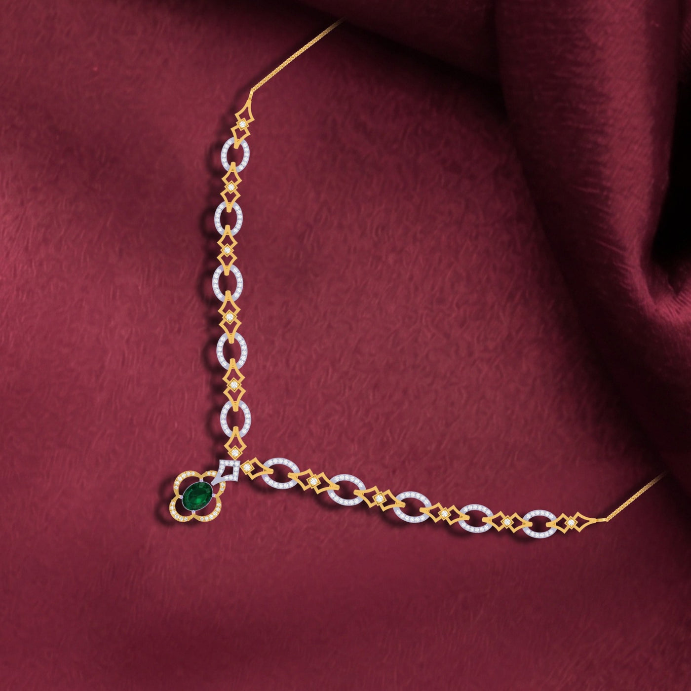 Gold and white chain necklace with a green gemstone on a maroon fabric background