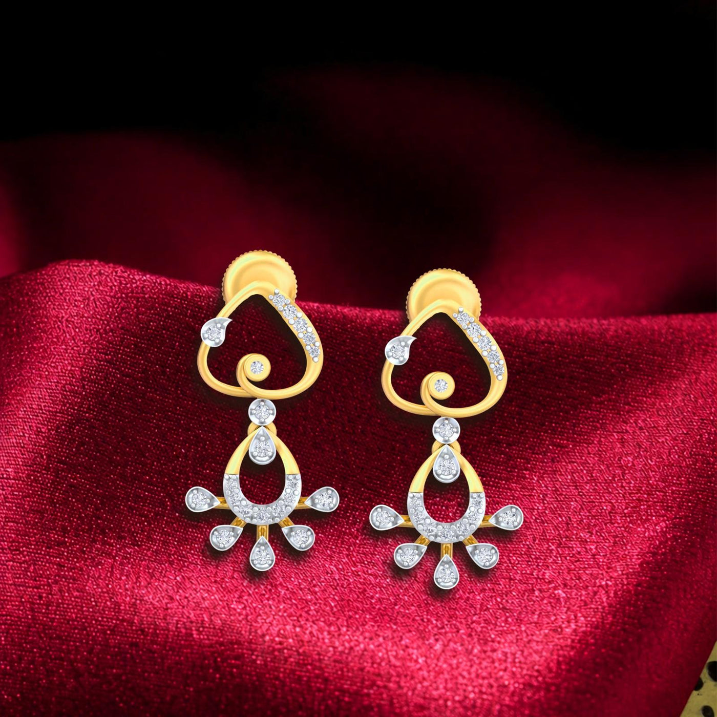Gold and diamond drop stud earrings on a red fabric background