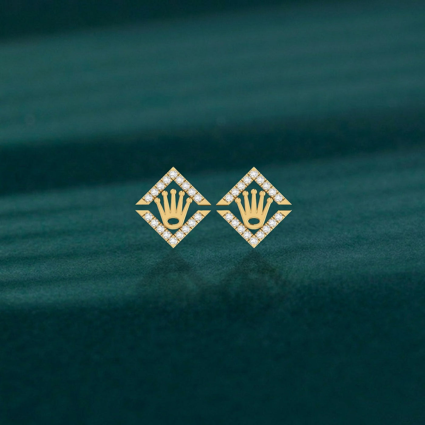 Pair of yellow gold and diamond crown-design stud earrings on a teal background.