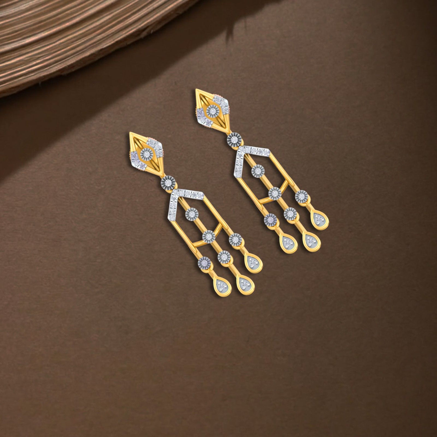 Gold and diamond dangler earring on a brown background.