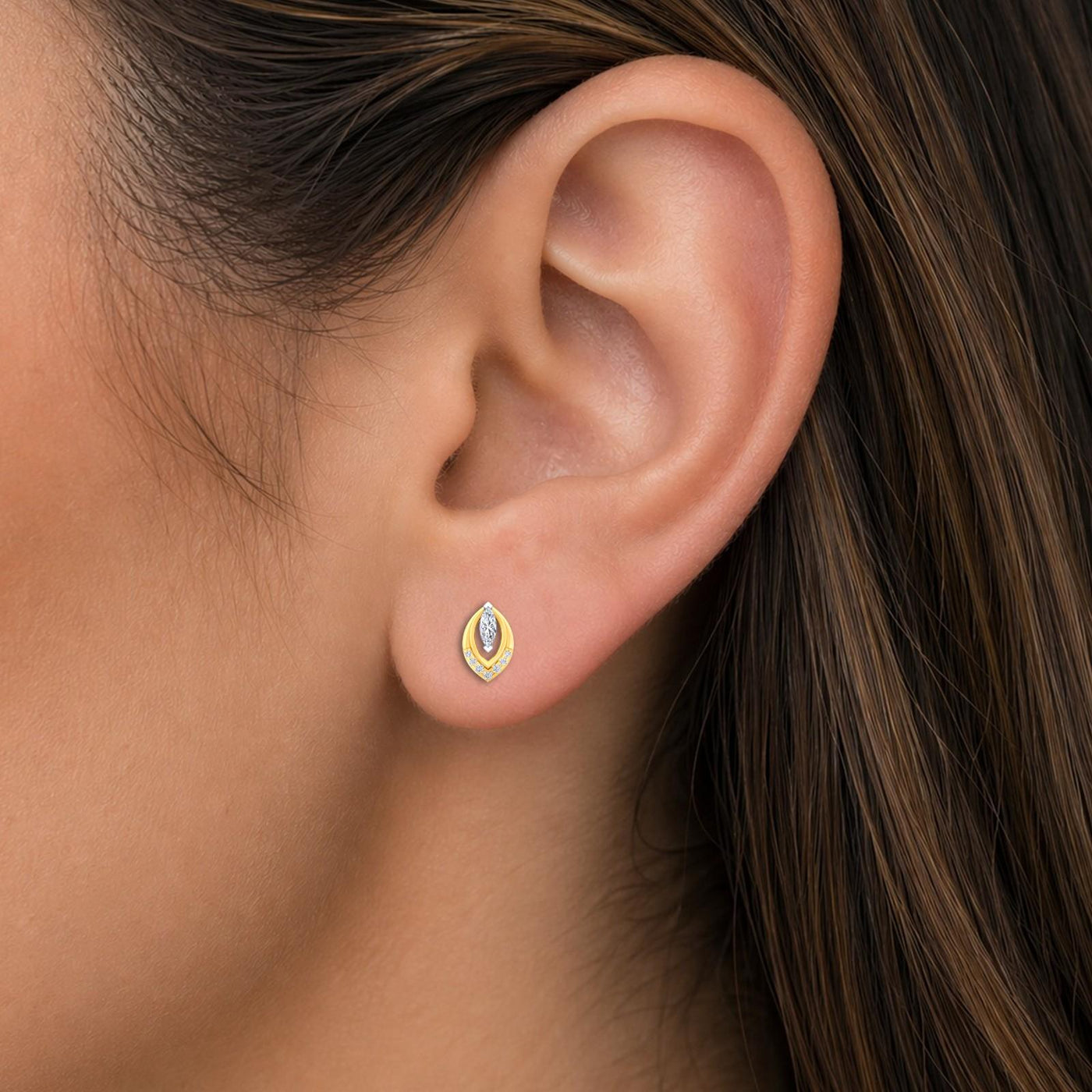 Close-up shot of a gold and diamond stud earrings with marquise-design.