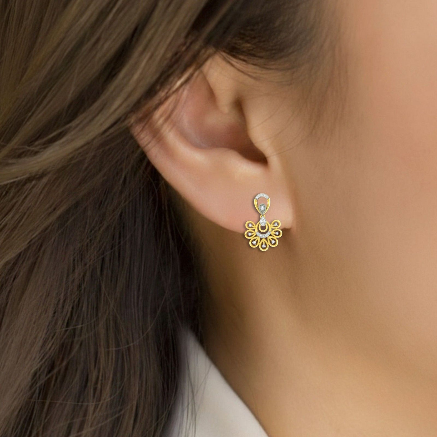 Close-up shot of a gold-toned dangler earrings with intricate floral and circular design