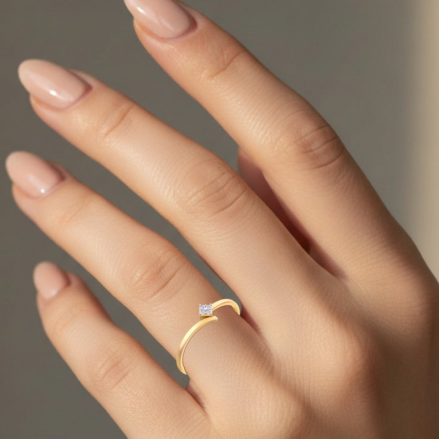 Gold ring with a diamond on a hand against a neutral background