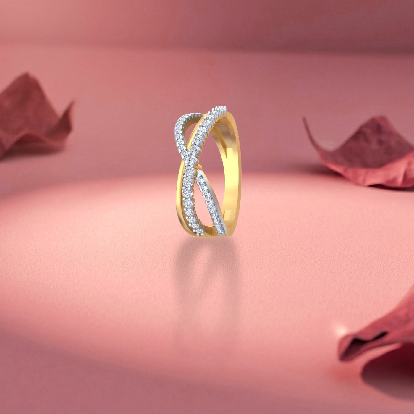 Gold and diamond ring on a pink surface with red leaves.