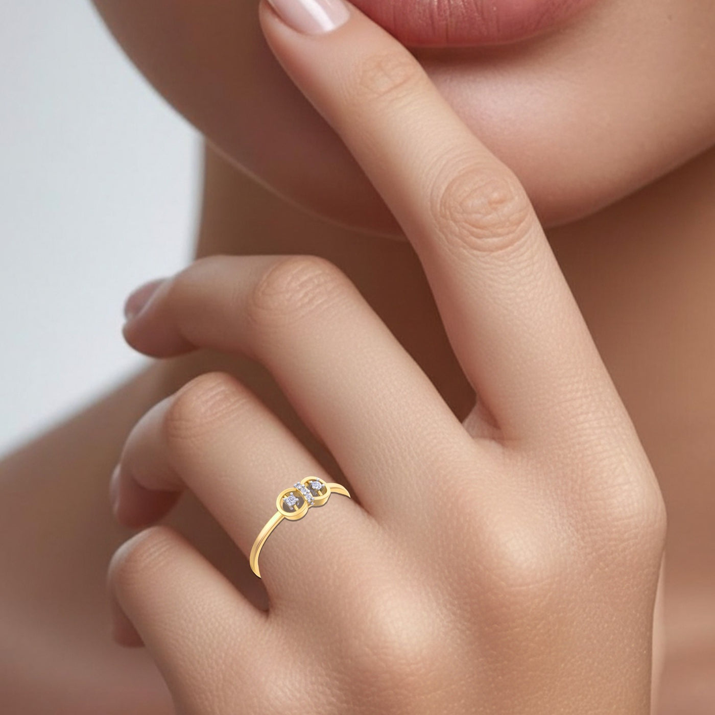 Gold ring with three diamonds on a finger against a neutral background