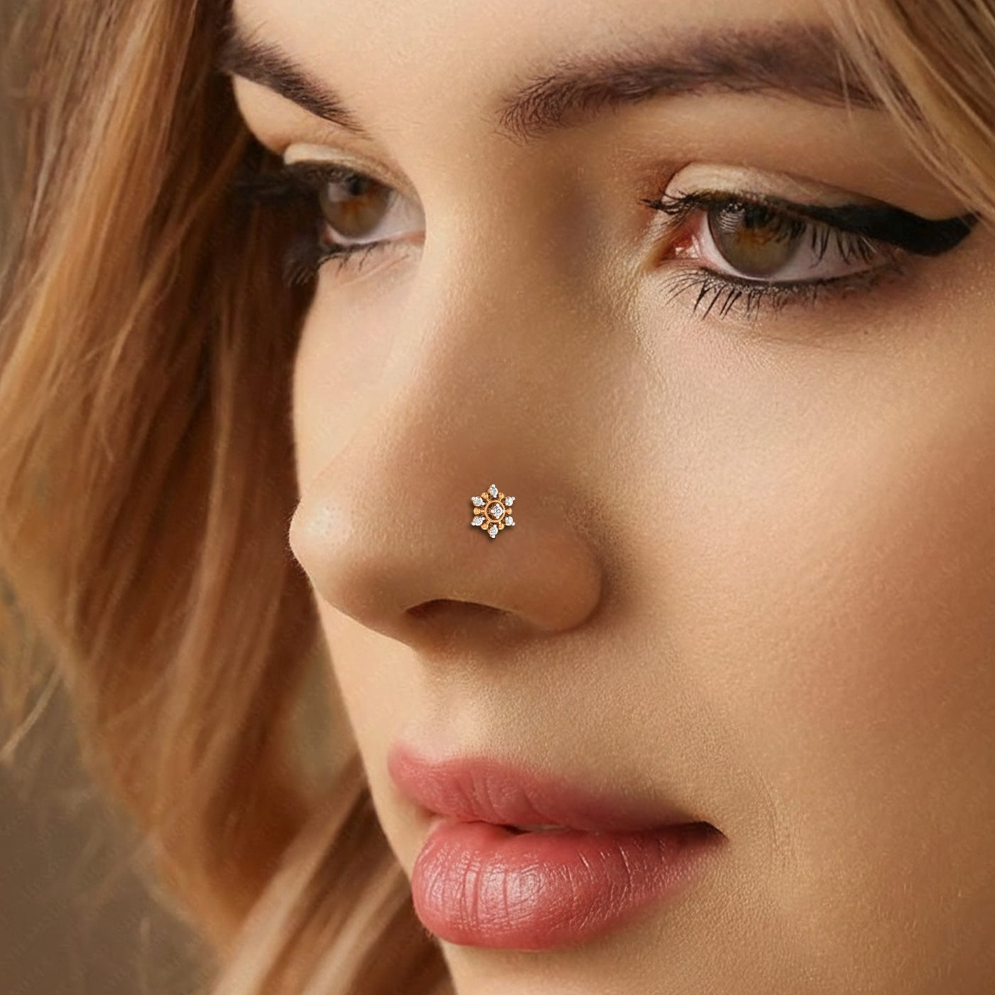 Close-up of a woman's face wearing a nose pin with a small diamond-like stone.