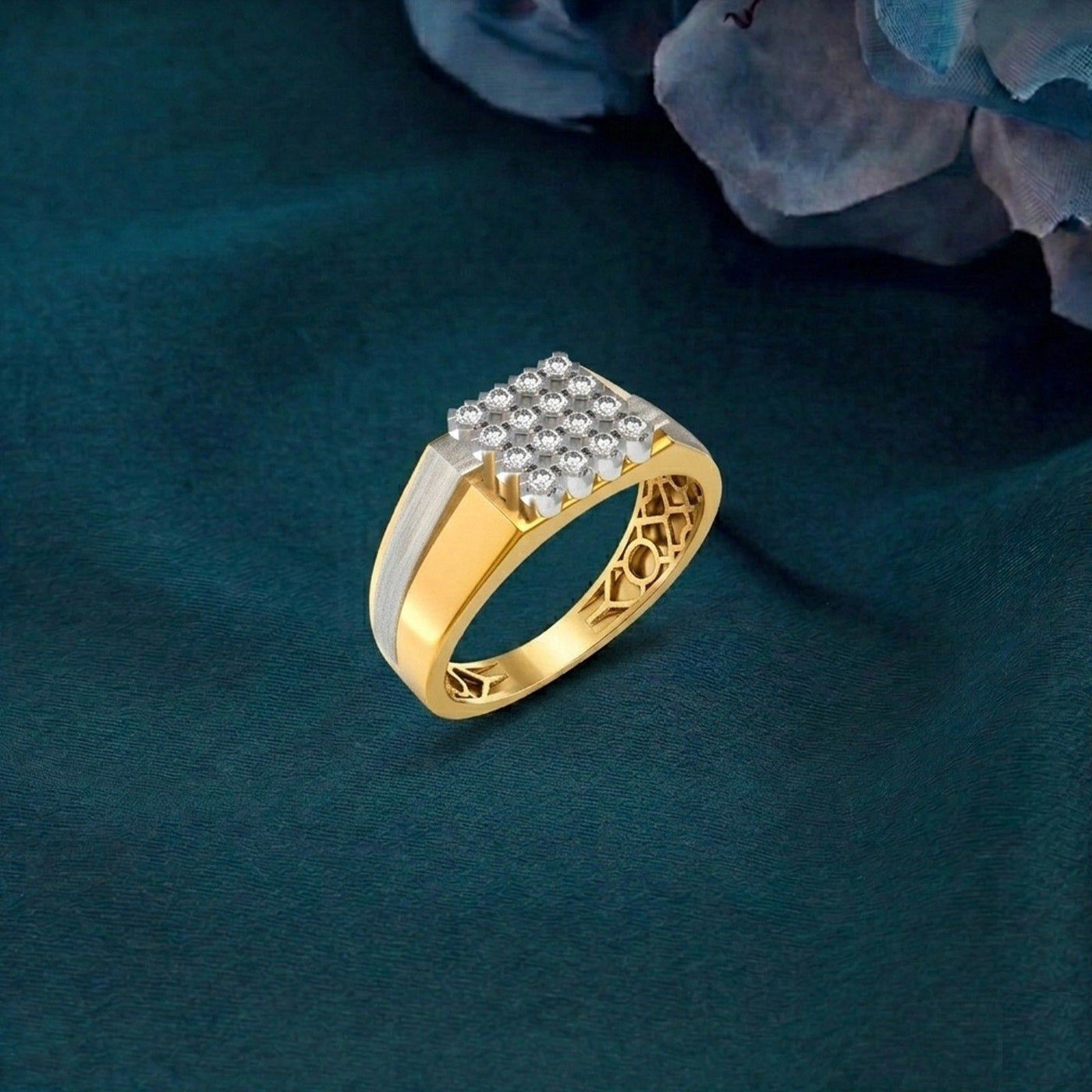 A gold ring with a rectangular, displayed on a dark teal fabric background.