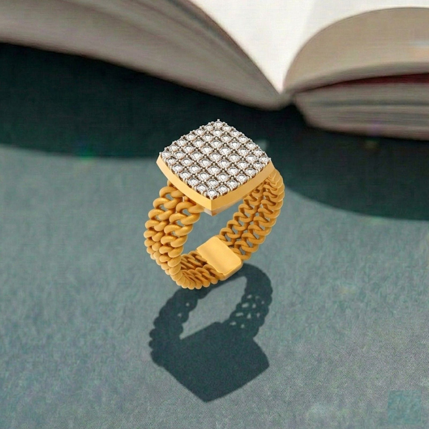 Gold ring with diamond-studded top on a textured surface
