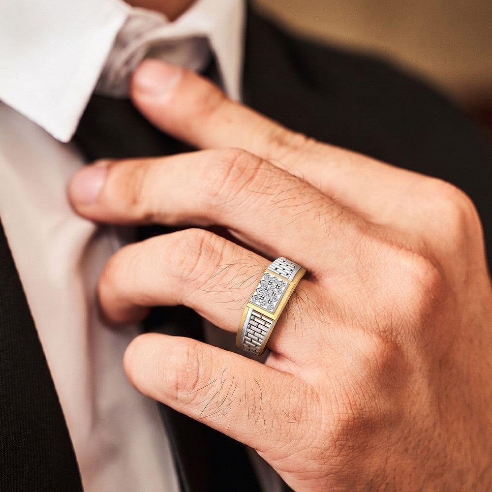 Hand wearing a gold ring with diamonds, adjusting a tie.