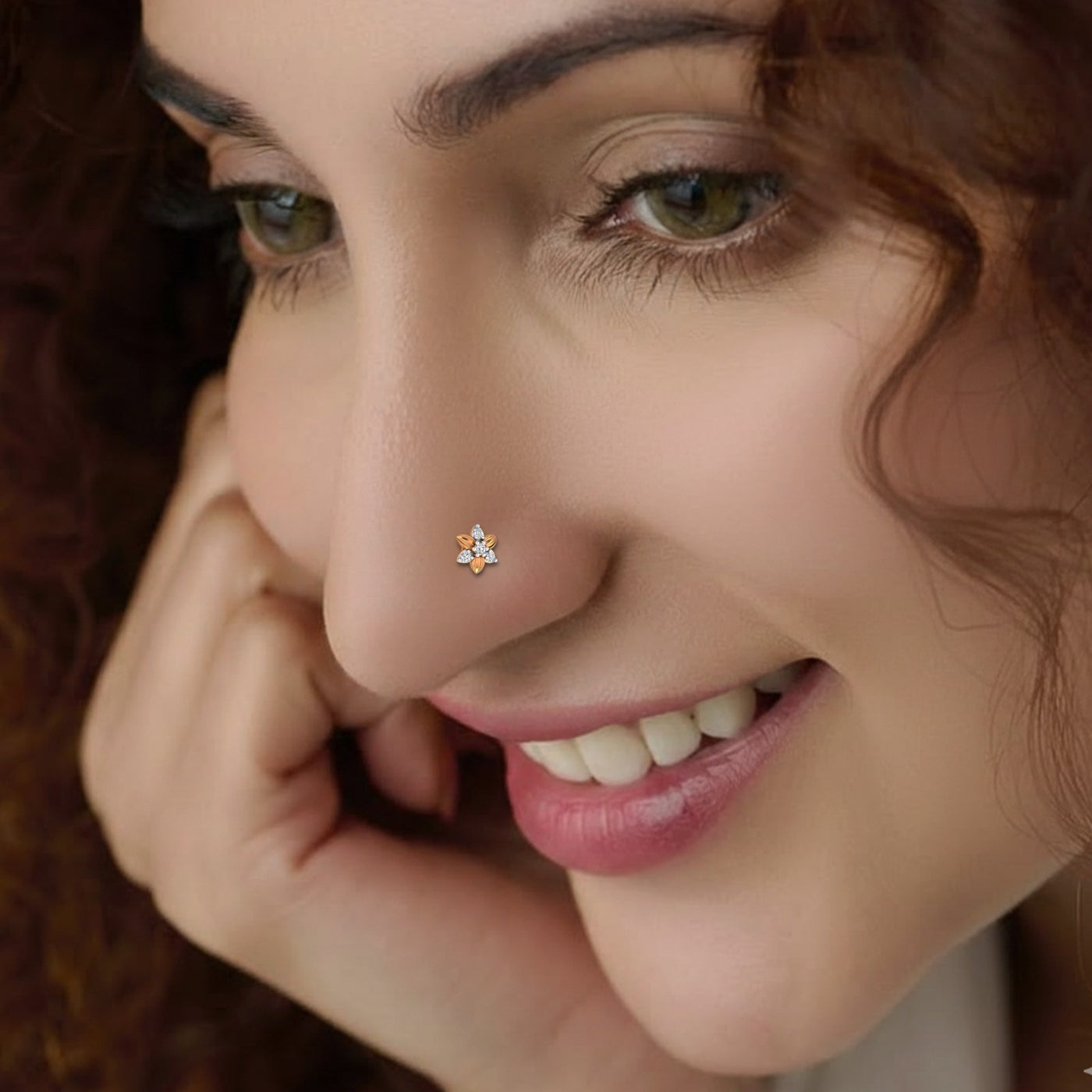 Close-up of a woman with a nose pin and a smile.