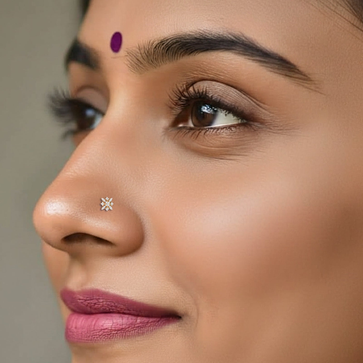 Close-up of a woman's face with a nose pin and purple lip color.