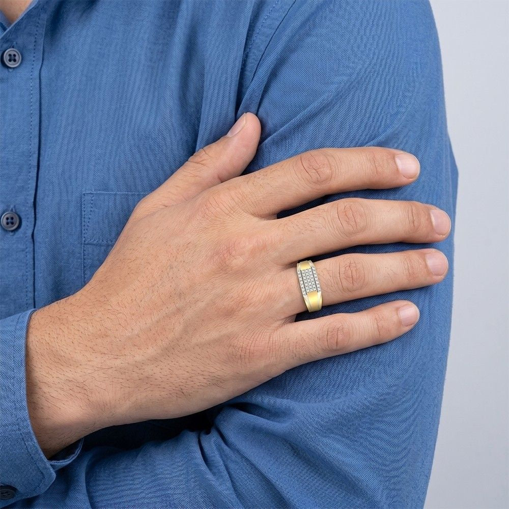 Hand wearing a gold ring with diamonds on a blue shirt background.