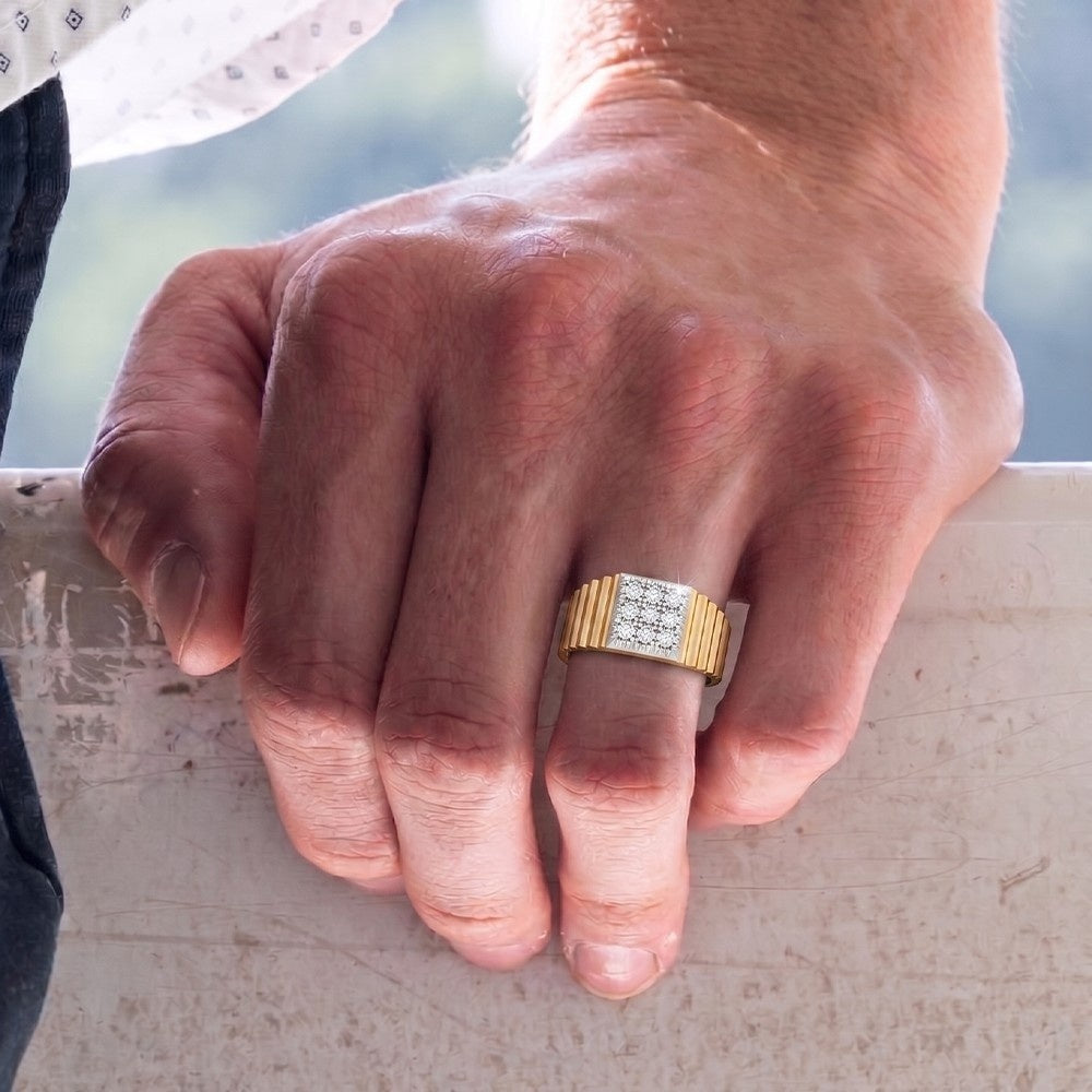 Hand wearing a gold ring with a diamond design on a blurred natural background