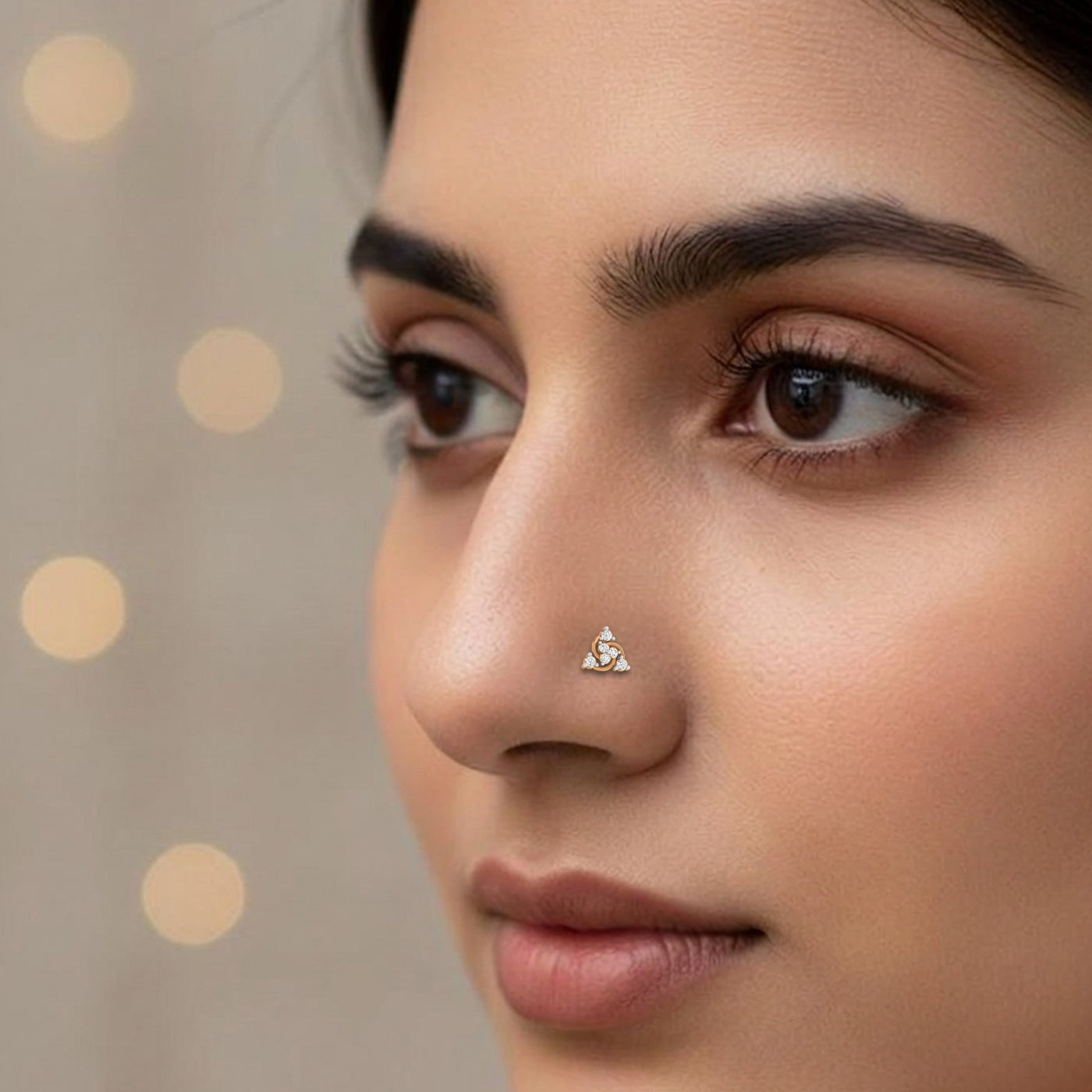 Close-up of a woman's face with a nose pin against a neutral background