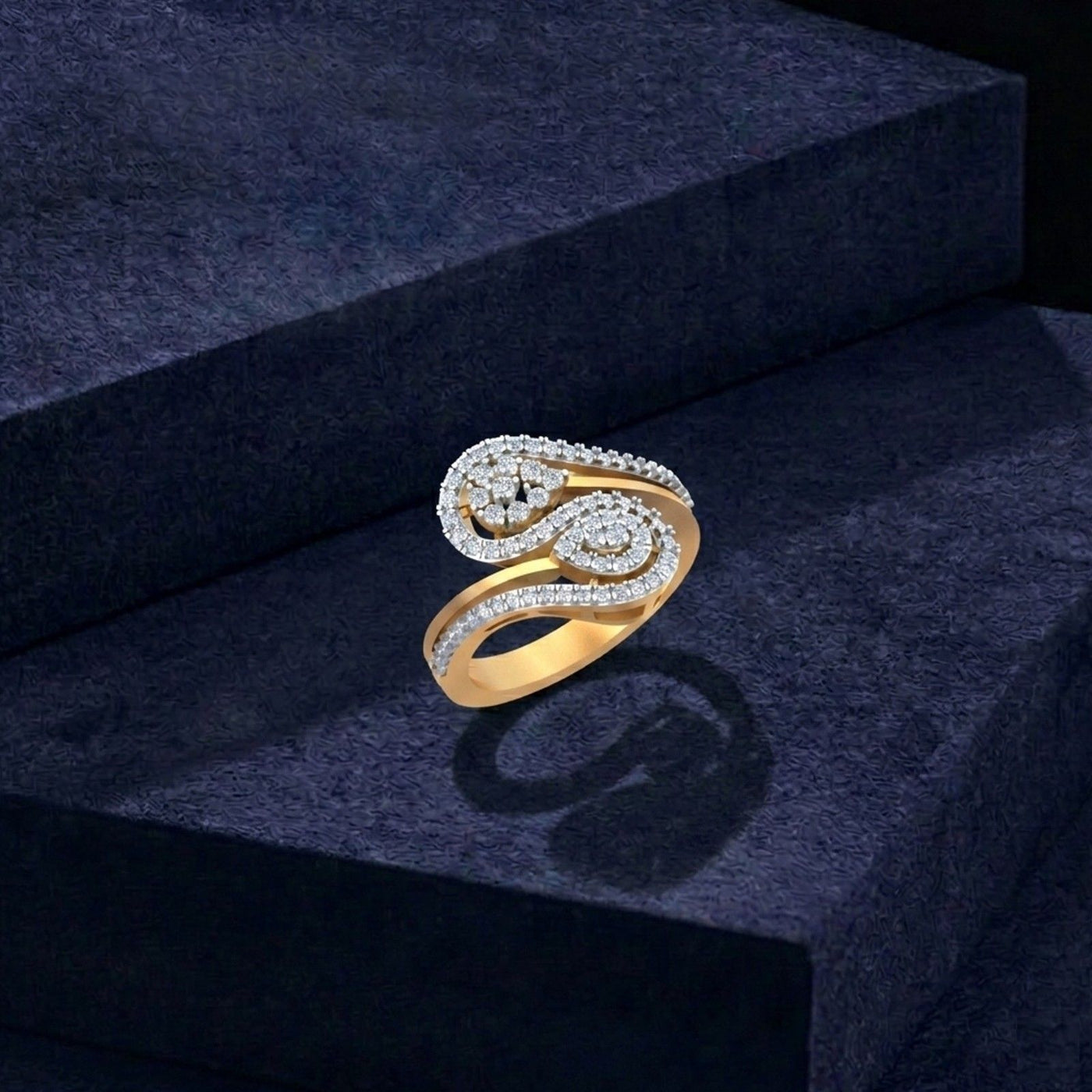 Gold and diamond gold spiral ring, shown on a blue surface.