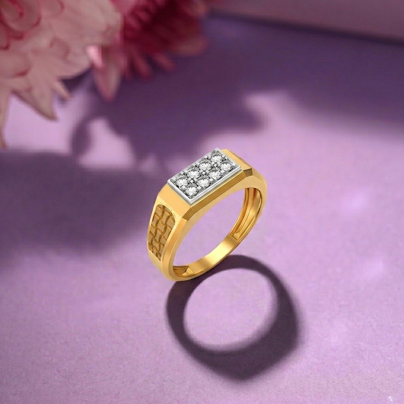 Gold ring with diamond accents on a purple surface