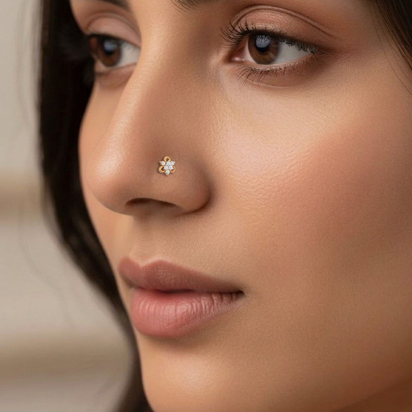 Close-up of a woman's face with a nose pin featuring a floral design.