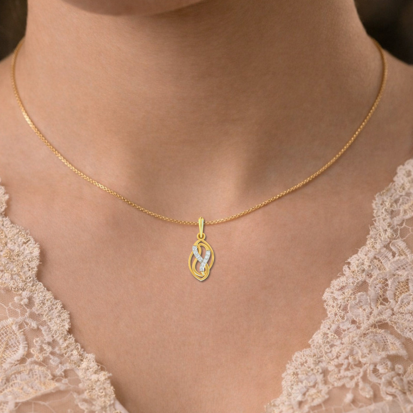 Gold necklace with a pendant worn by a person in a lace garment