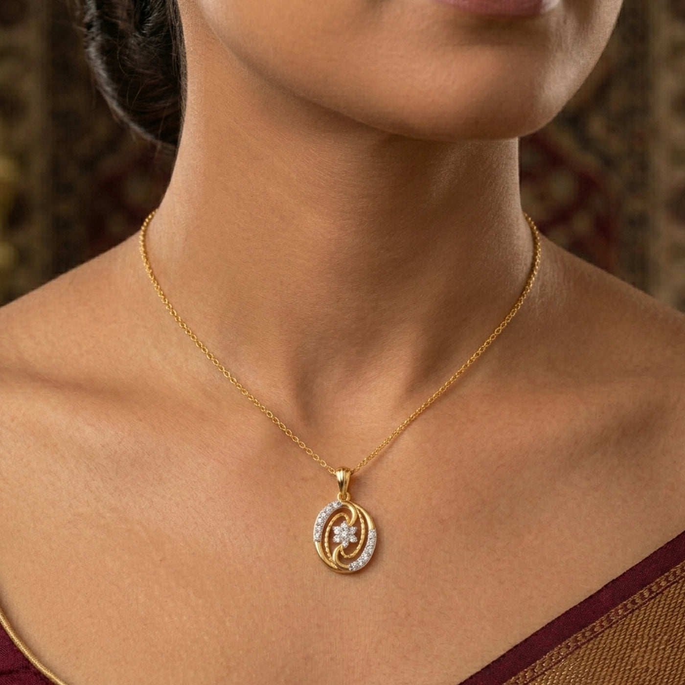 Gold and diamond pendant on a women wearing a brown saree.