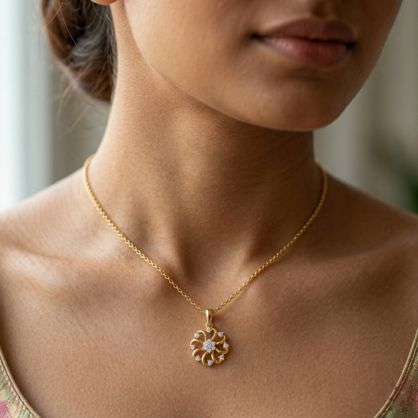 Close-up of a person wearing a gold necklace with a floral pendant.