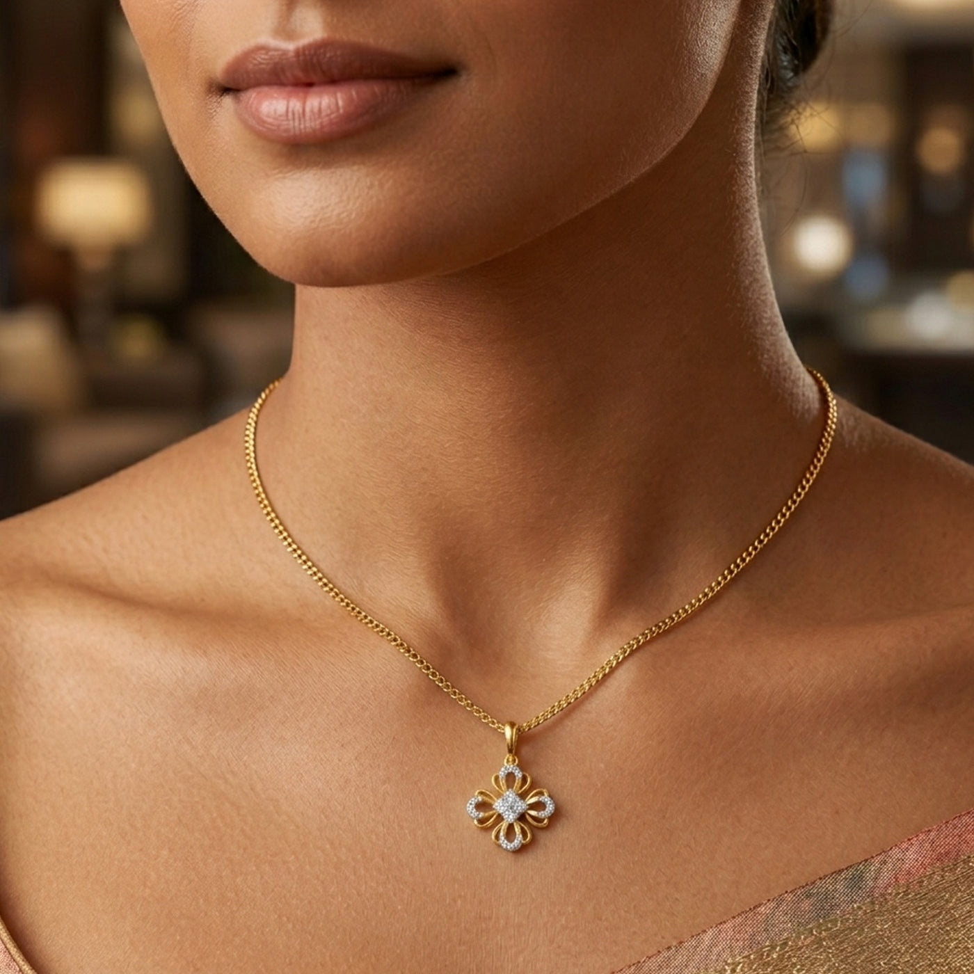 Close-up of a woman wearing a gold necklace with a floral pendant.