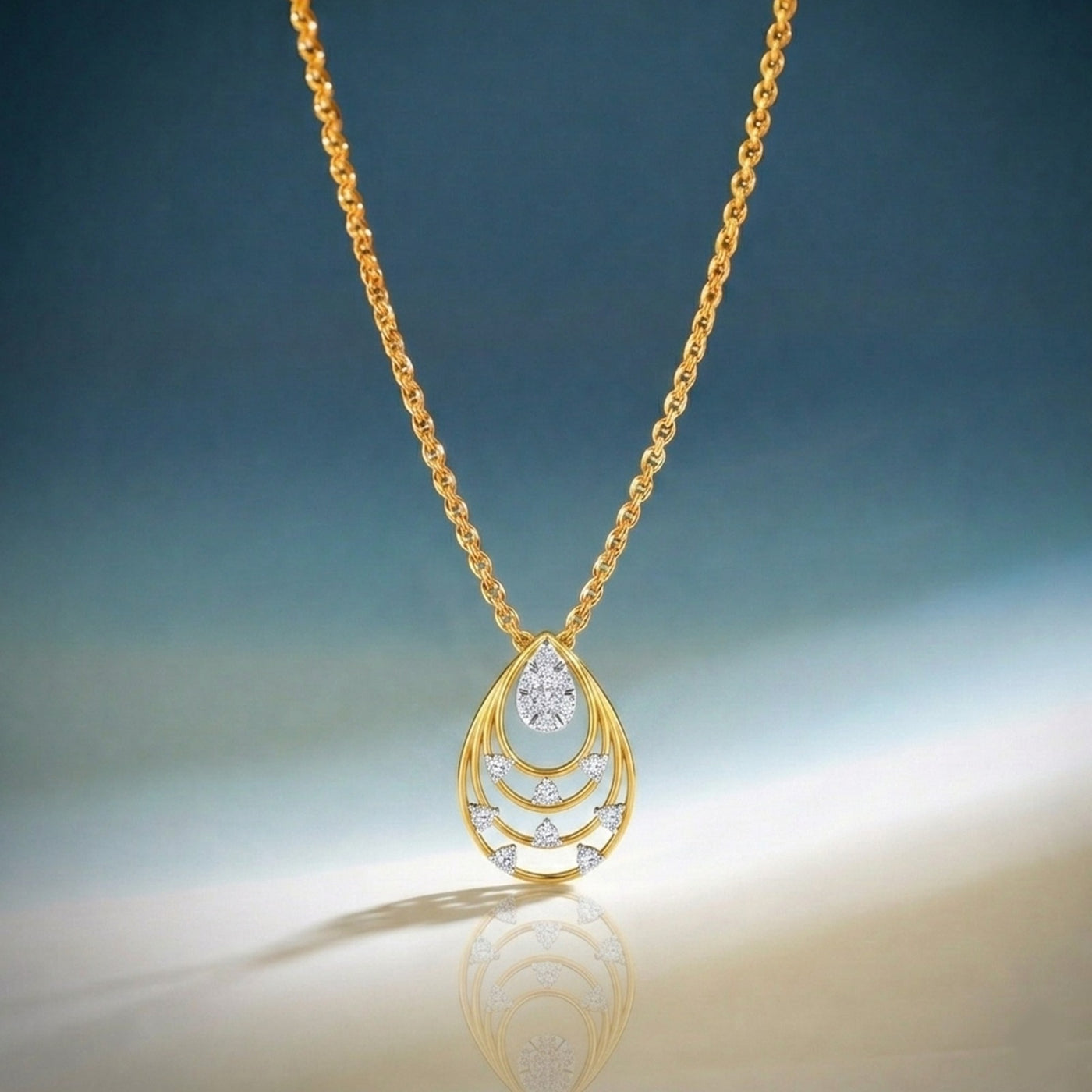 Gold necklace with a teardrop-shaped pendant on a gradient blue and beige background