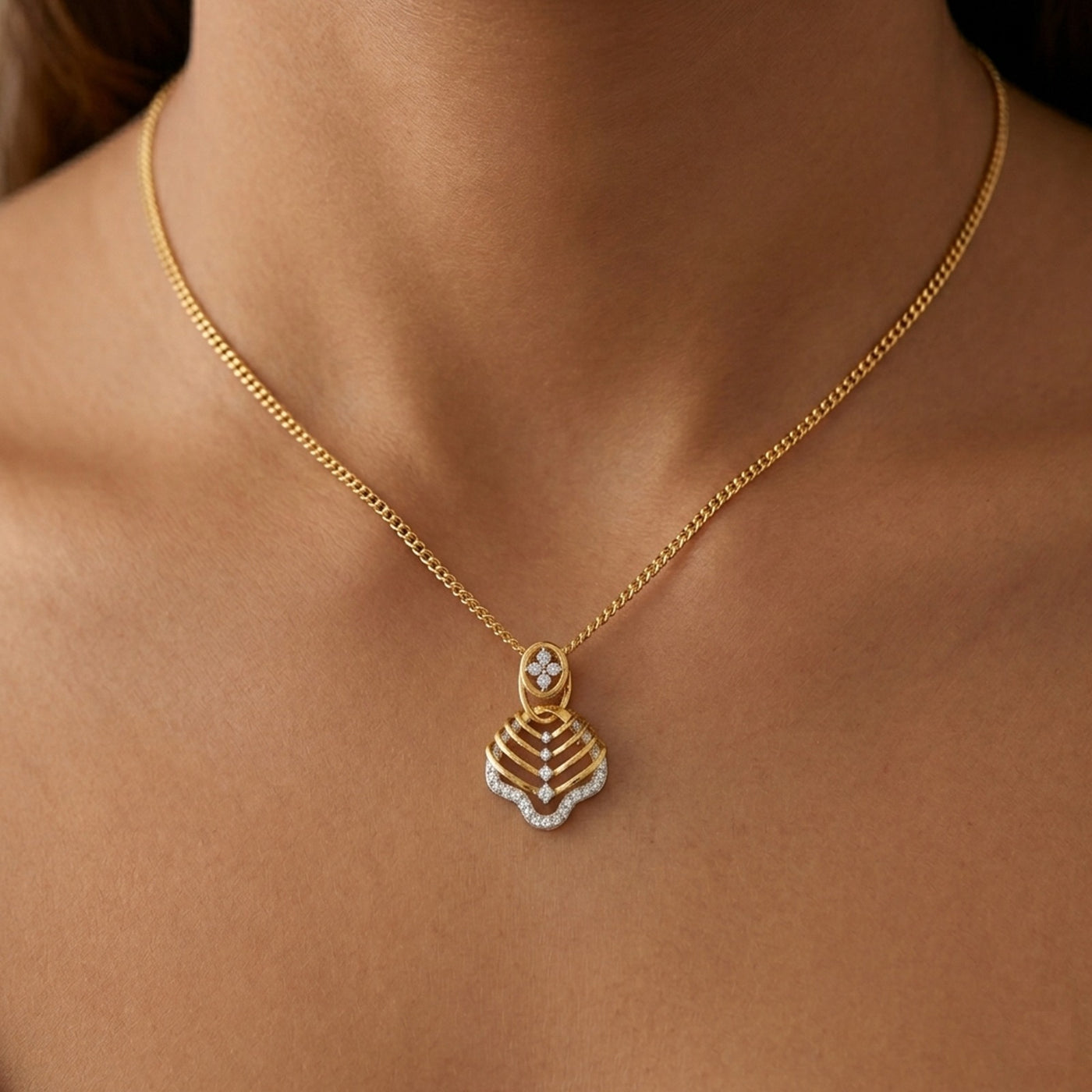 Gold necklace with a decorative pendant on a person's neck