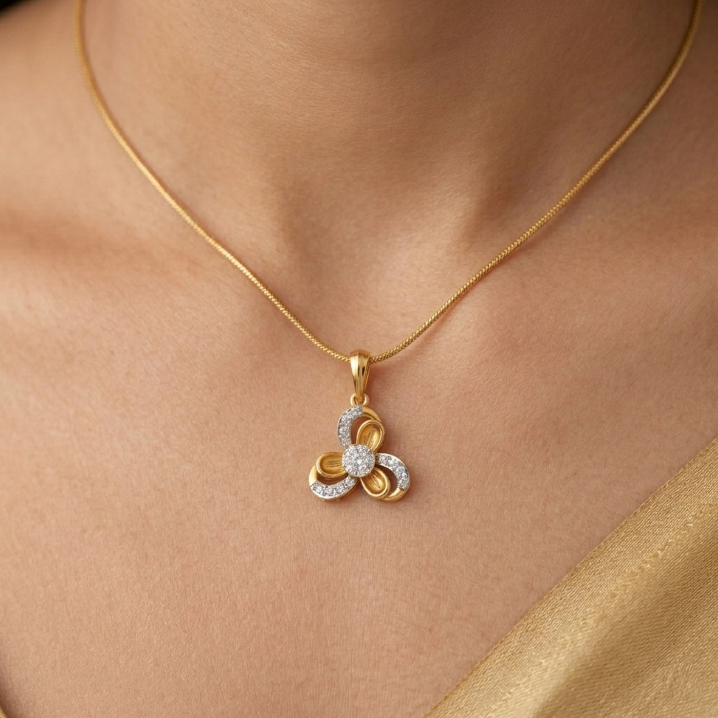 Gold necklace with a floral pendant on a person's neck