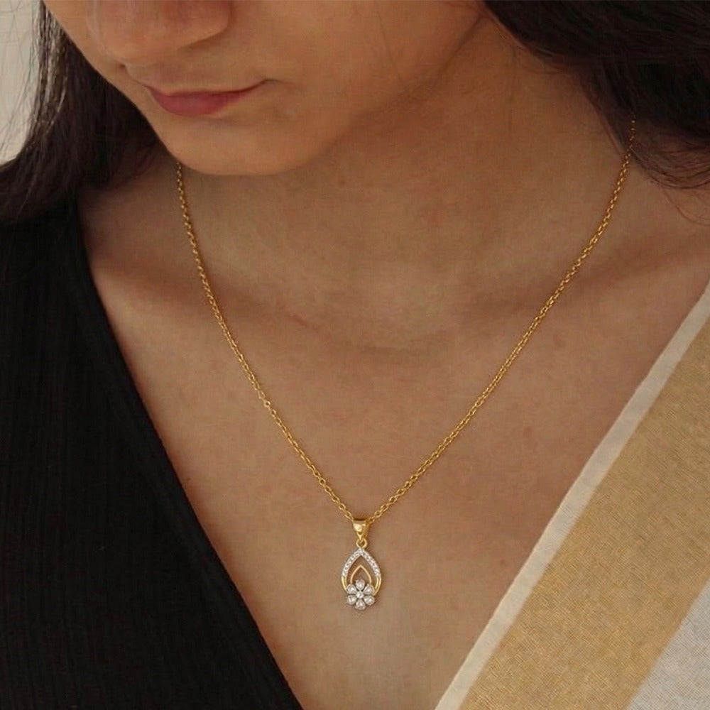 Gold necklace with a pendant worn by a person