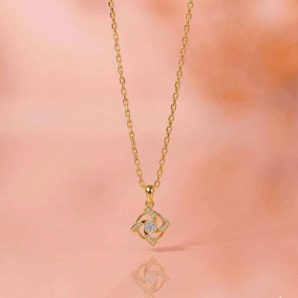 Gold necklace with a diamond pendant on a pink background