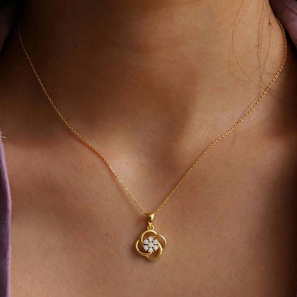 Gold with a floral pendant on a person's neck
