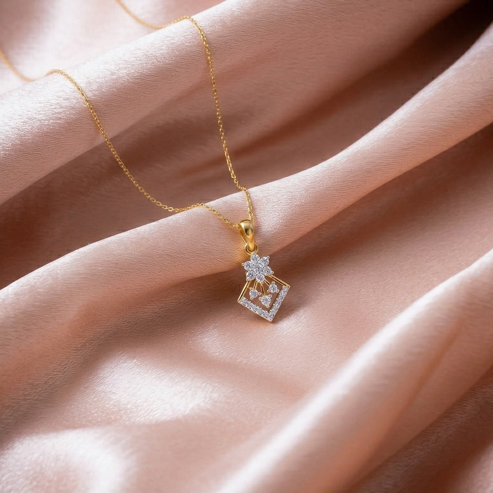 Gold and diamond pendant on a soft pink fabric background