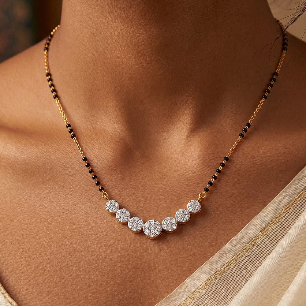 A close-up of a woman's neck wearing a gold and diamond necklace.