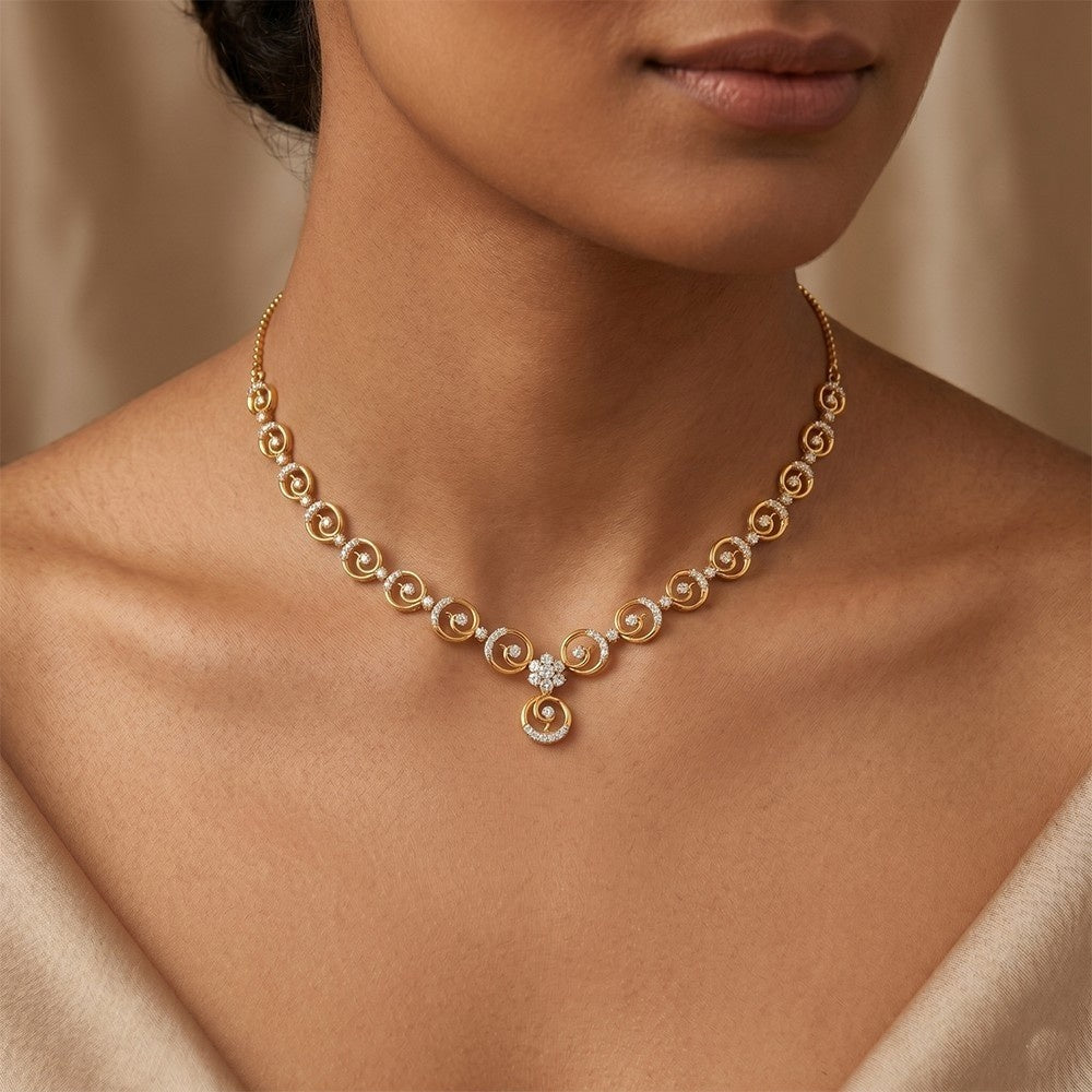 Gold and diamond necklace with circular design and central floral design on a person wearing.