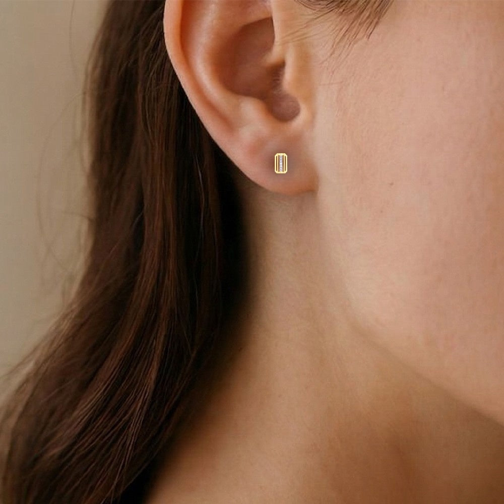 Close-up shot gold and diamond stud earring.