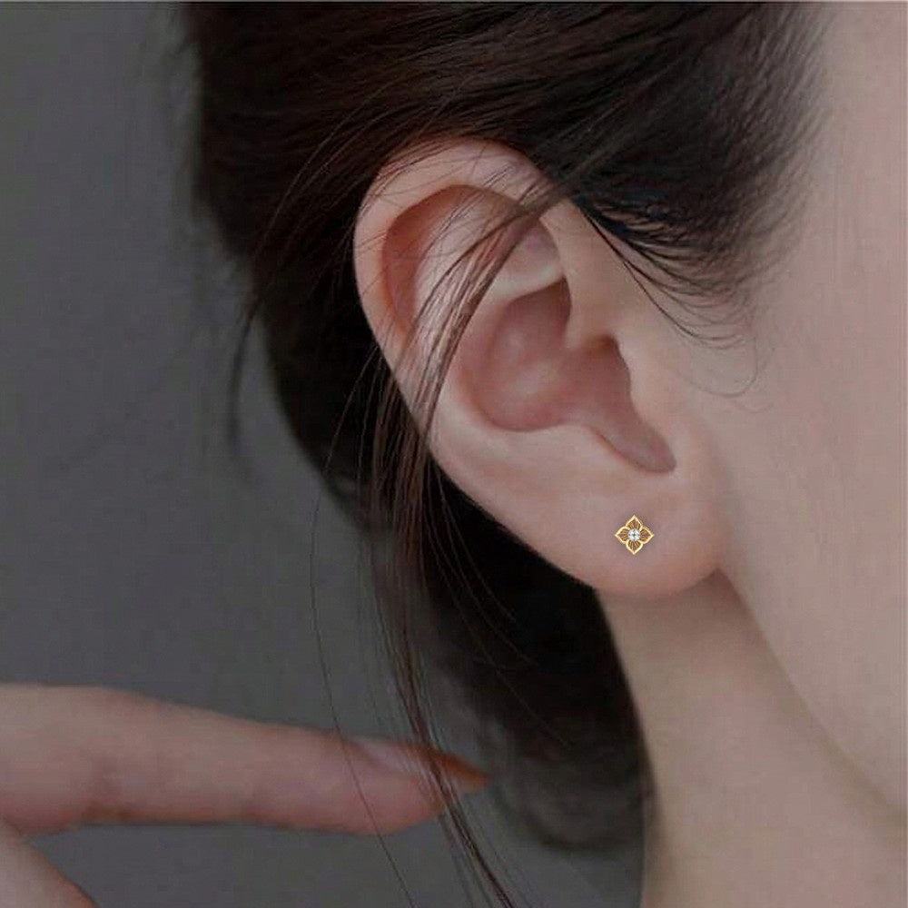 Close-up shot gold and diamond floral stud earring.