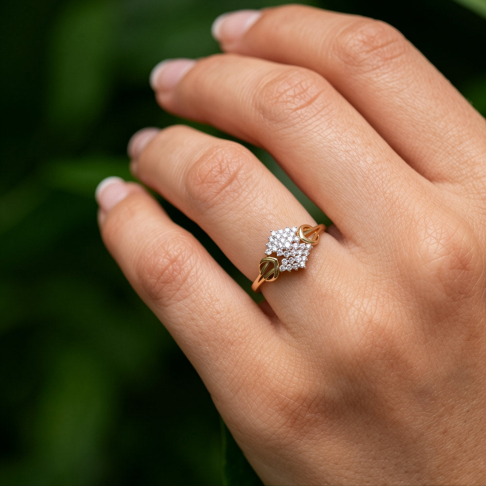 Rose gold ring with diamonds on a hand against a blurred green background