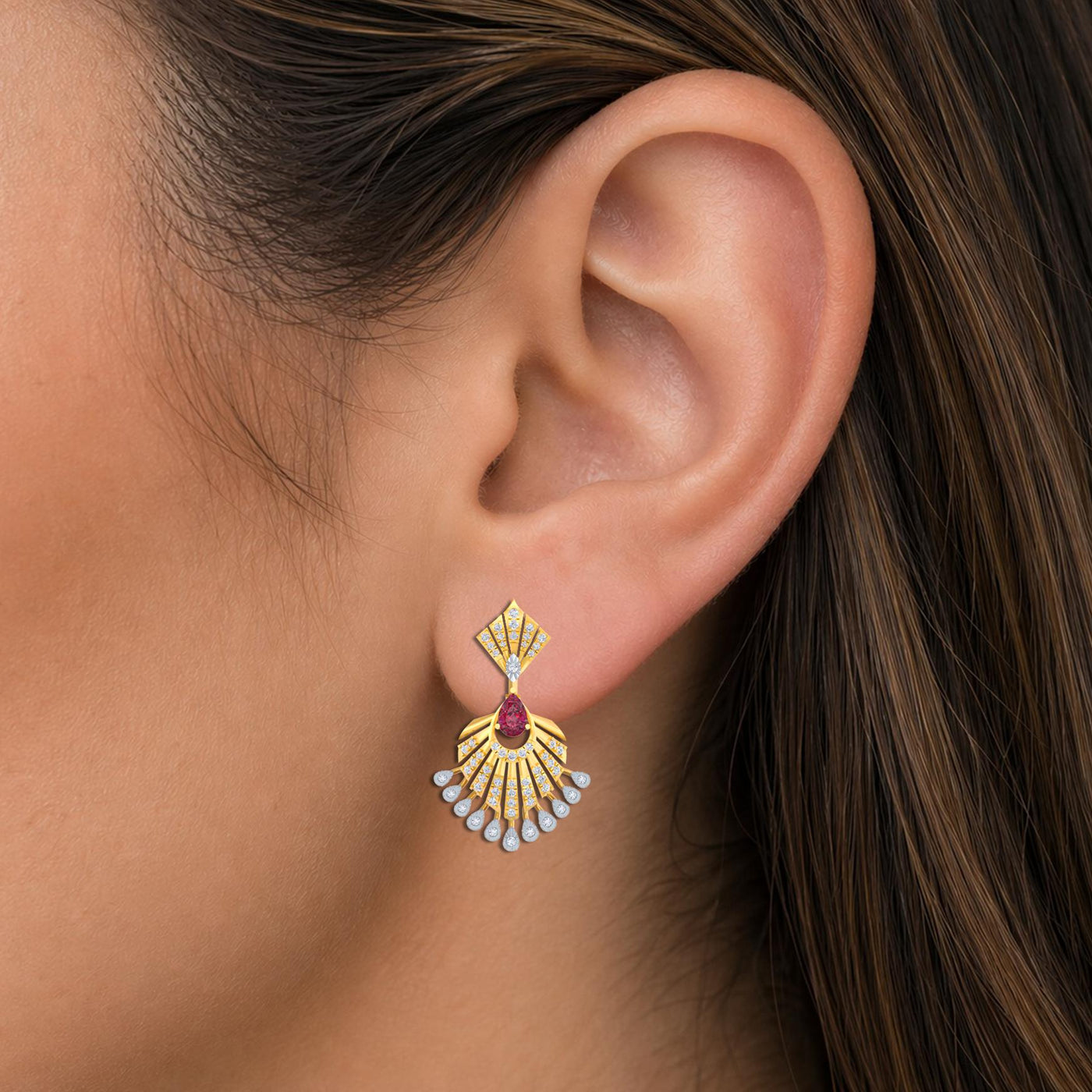 Close-up shot of a gold and diamond earrings with a floral design and a central ruby gemstone.
