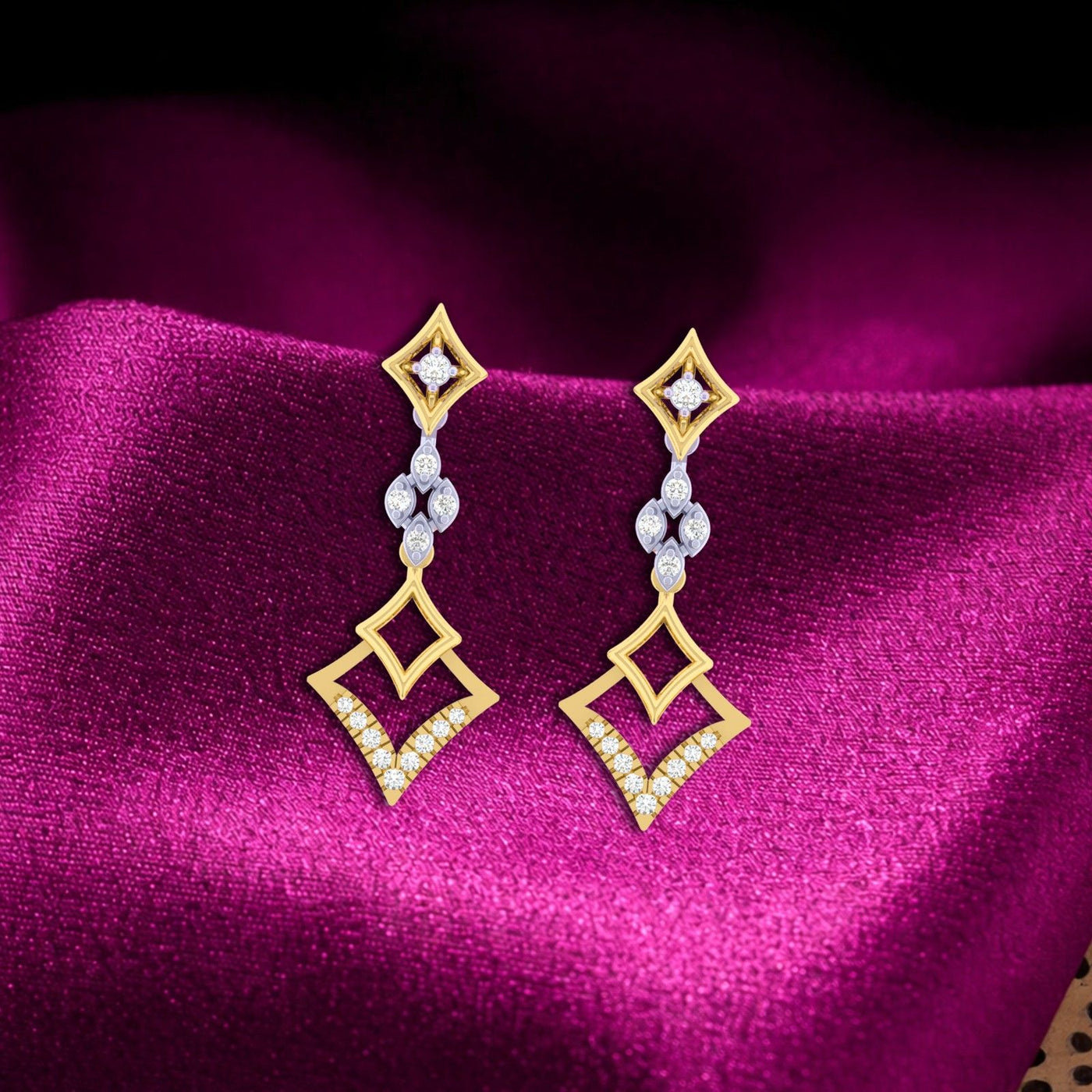 Gold and diamond earrings on a purple fabric background
