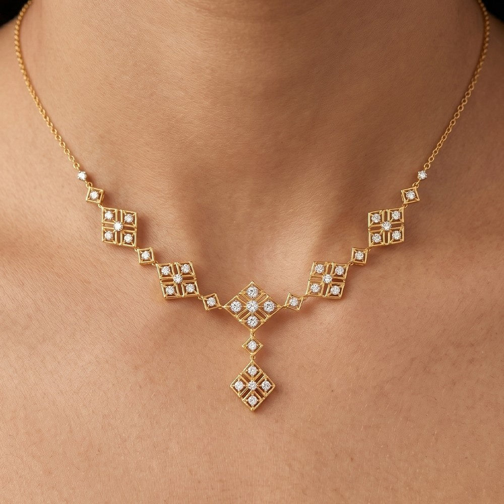 Gold necklace with diamond accents on a person's neck.