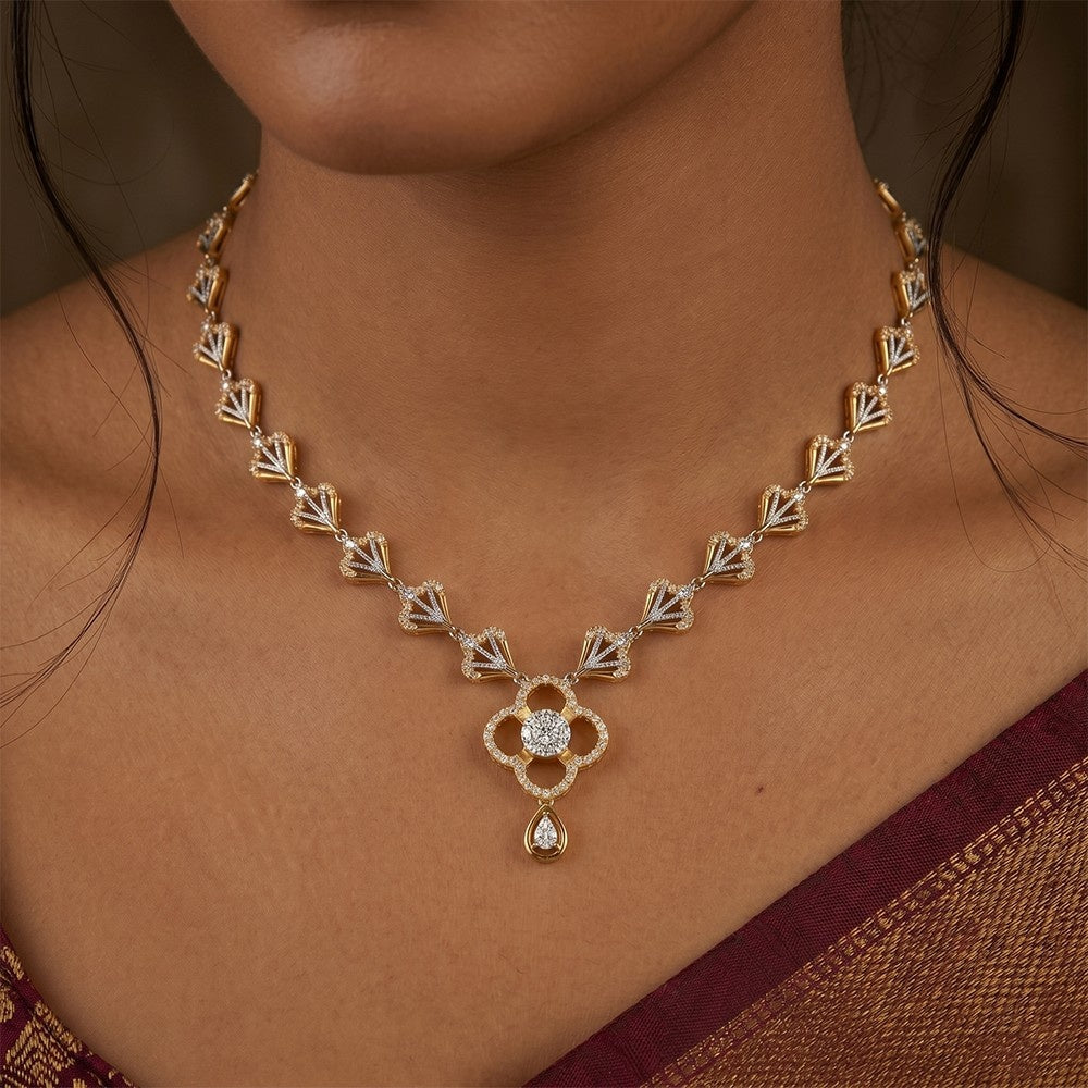 Gold necklace with a pendant on a person wearing a brown saree