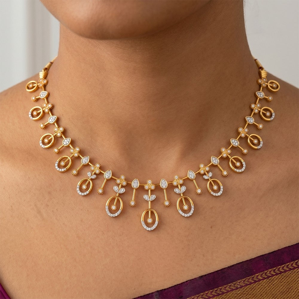 Gold necklace with floral designs on a person wearing a purple saree.