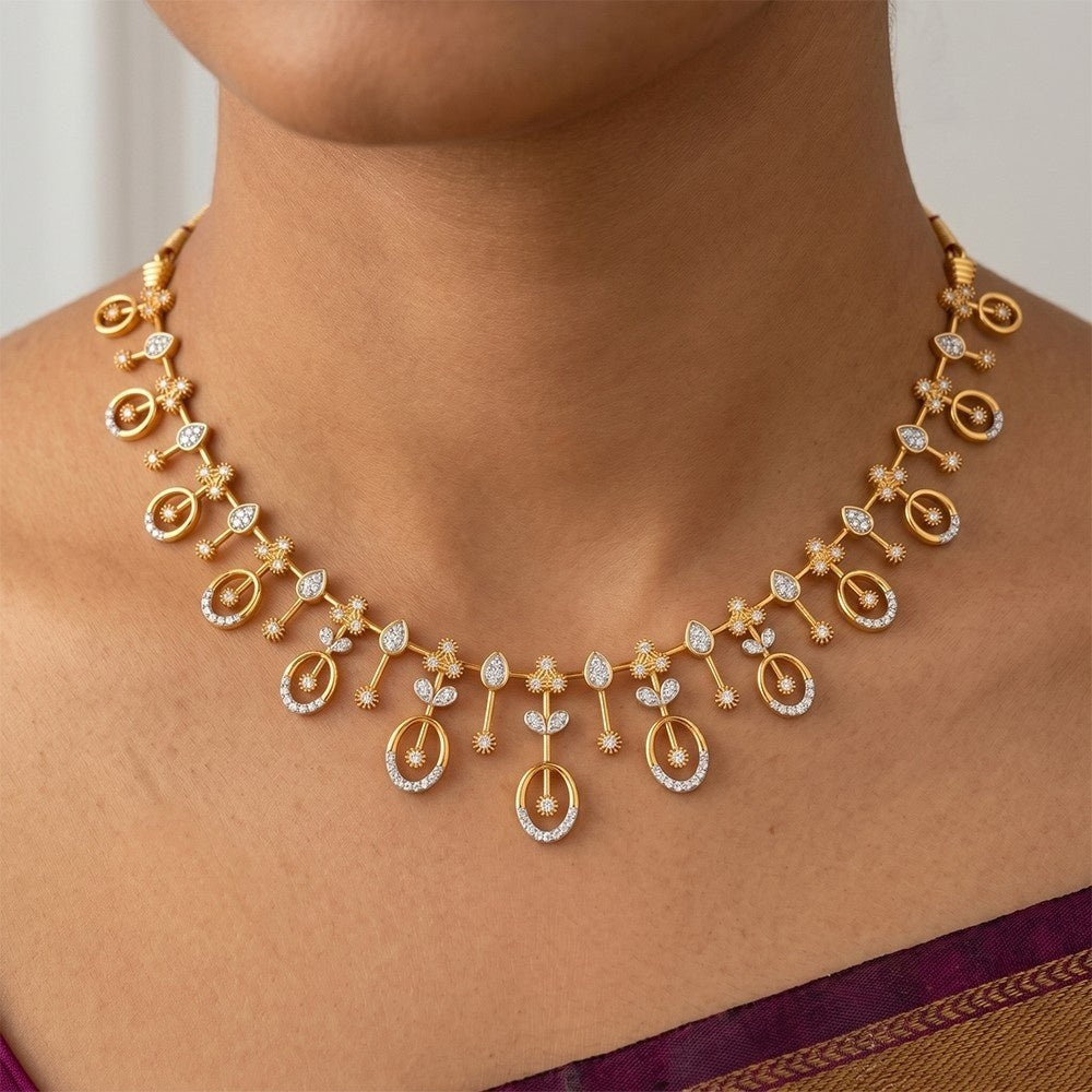 Gold necklace with floral designs on a person wearing a purple saree.