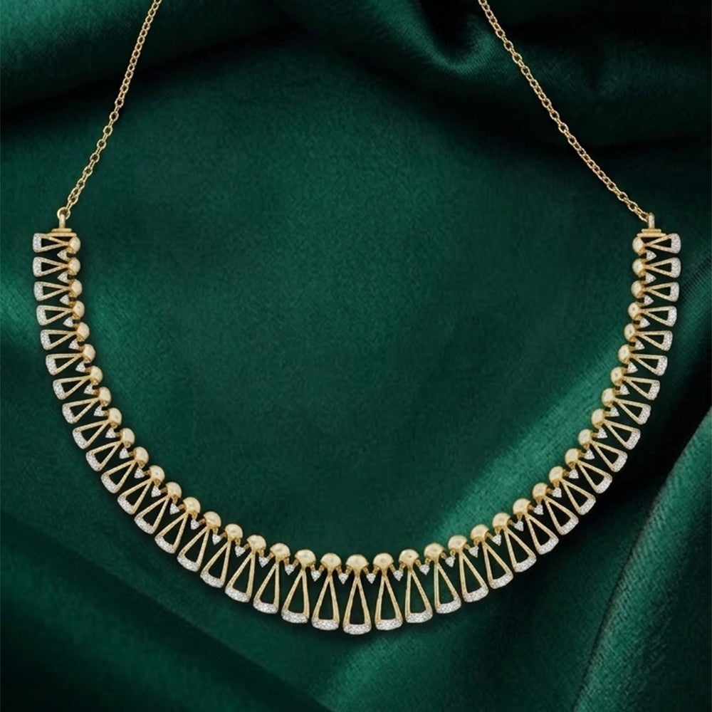 A gold necklace with a geometric fan and bead design, displayed on a draped dark green satin fabric.