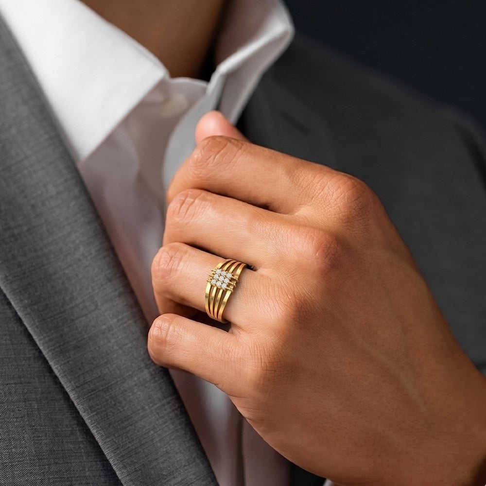 Hand wearing a gold ring with a gray suit background.