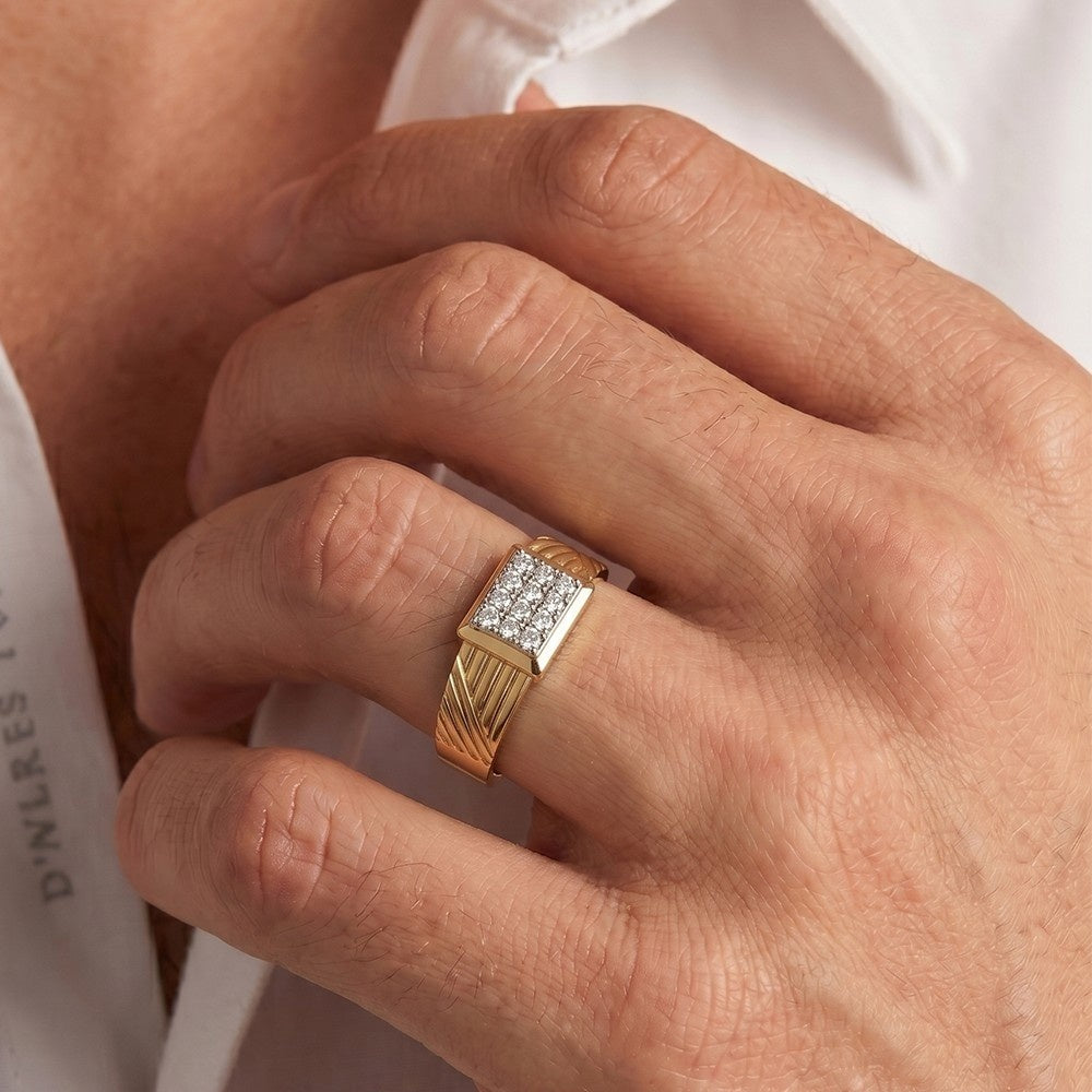 Gold ring with diamonds on a person's finger against a white background