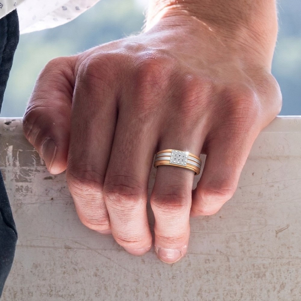 Hand wearing a gold and diamond ring on a blurred natural background