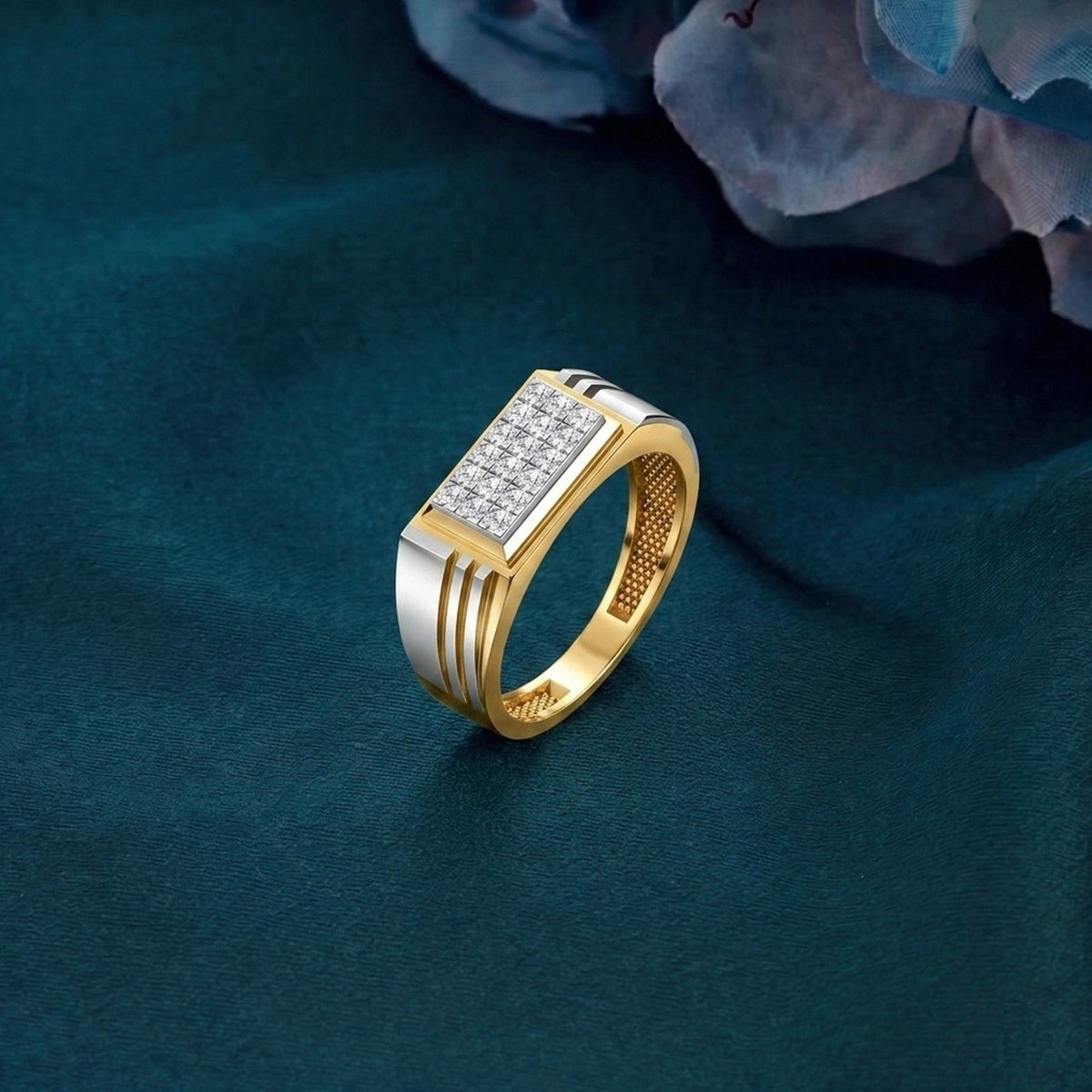 Gold and diamond band ring on a in teal surface.