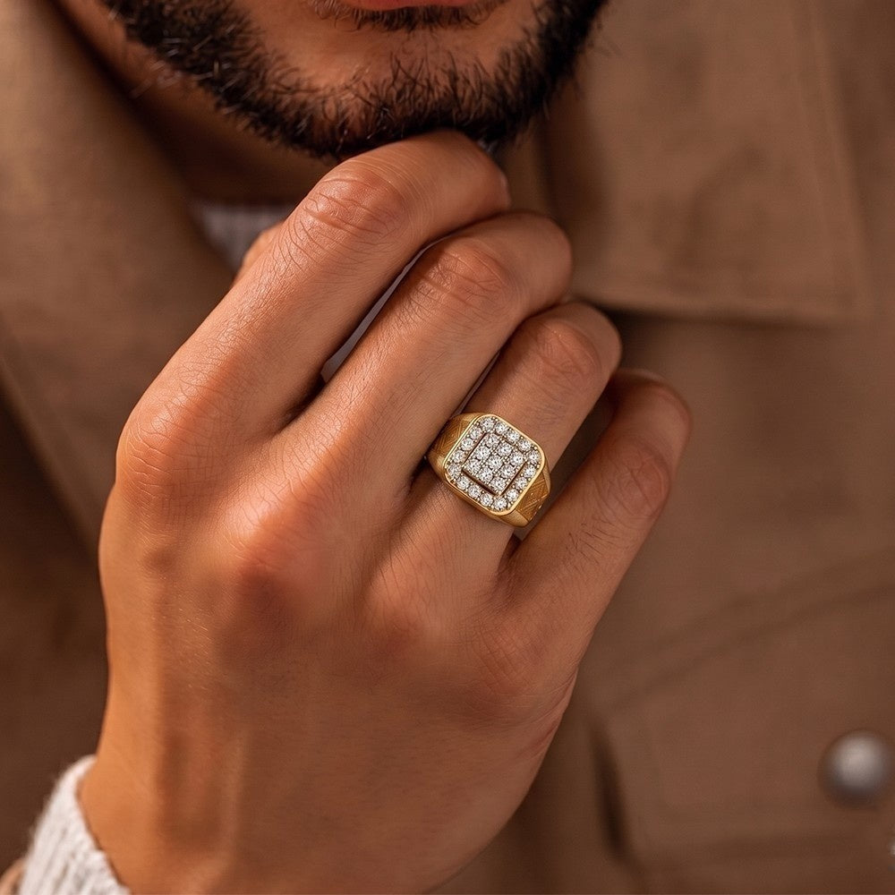 Hand wearing a gold ring with diamonds, against a brown background
