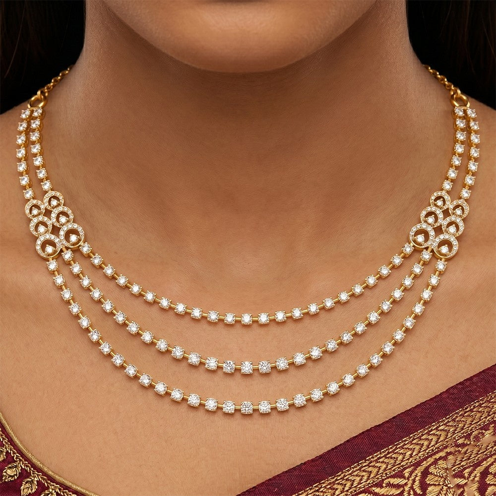 A person wearing a three-strand yellow gold and diamond layered necklace